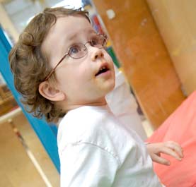 A little boy with glasses in a classroom