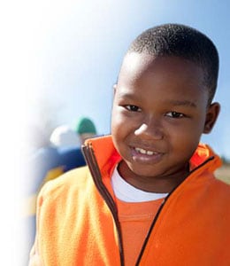 A happy young boy in an orange shirt