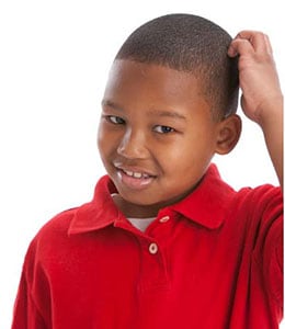 A young boy in a red shirt smiling 