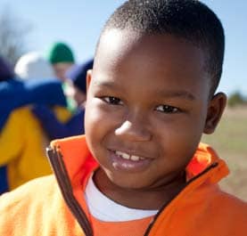 A young african american boy in an orange jacket