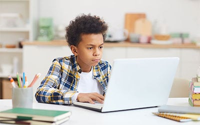 Teen studying at home on his computer
