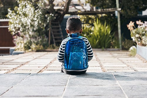 Boy sitting with backpack