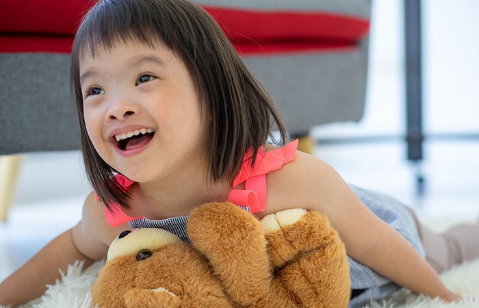 A little girl holding a teddy bear