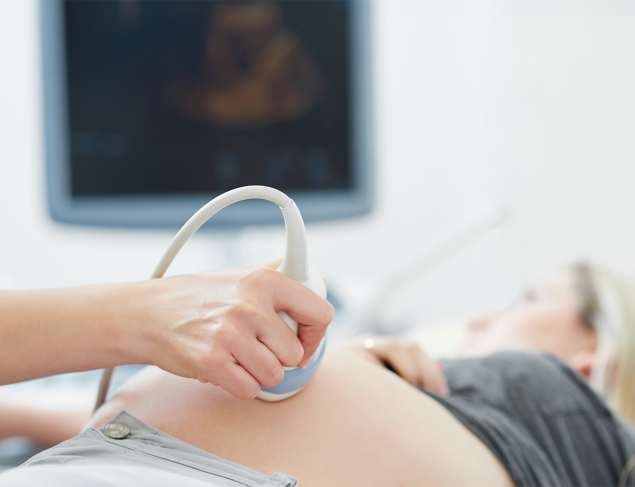 Doctor using ultrasound equipment screening of pregnant woman