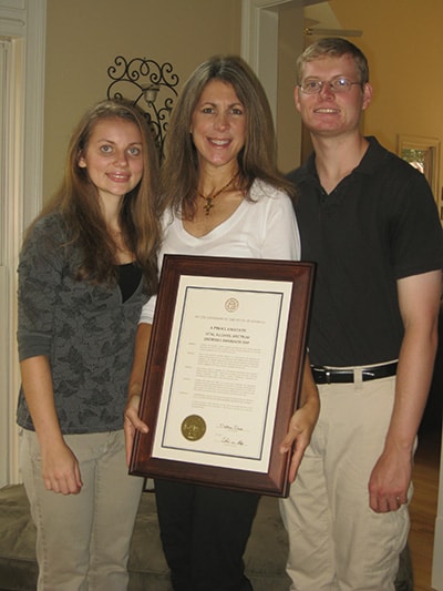 Sasha with his family with his wife holding a certificate.