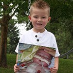 Teagan holding a picture of himself when he was younger