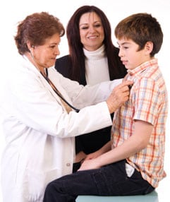 Doctora examinando a un niño mientras su madre observa