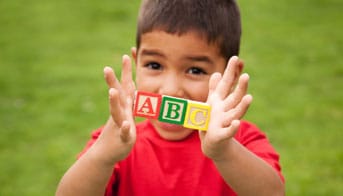 Boy holding A, B, and C toy blocks