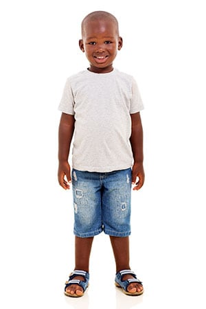 A young smiling boy wearning jean shorts