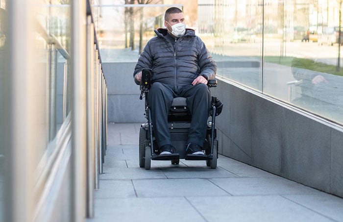 Man in a wheelchair wearing face mask