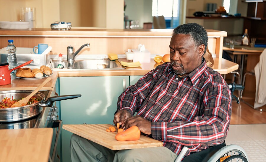 An African American man in a wheelchair making dinner