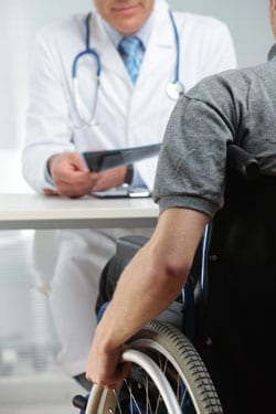 A person in a wheelchair talking with his doctor