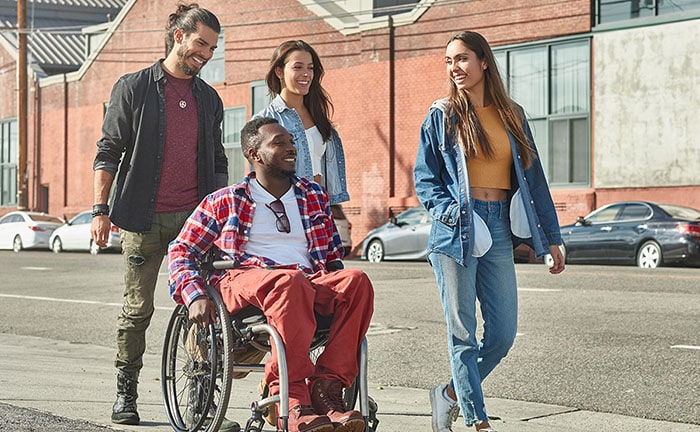 Hombre en una silla de ruedas paseando con sus amigos