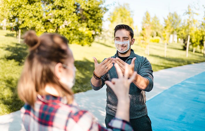 Young adults with hearing disability wearing special face mask for lip-reading