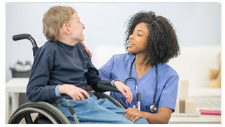 boy in wheelchair with healthcare provider