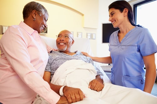 Nurse talking with elderly couple in hospital