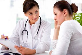 Female doctor and female patient looking over clipboard