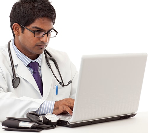 A doctor looking at a laptop