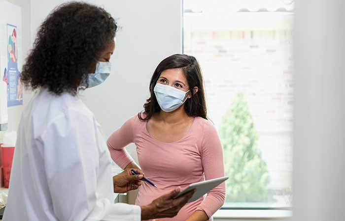 Woman meeting with her doctor wearing a protective mask.