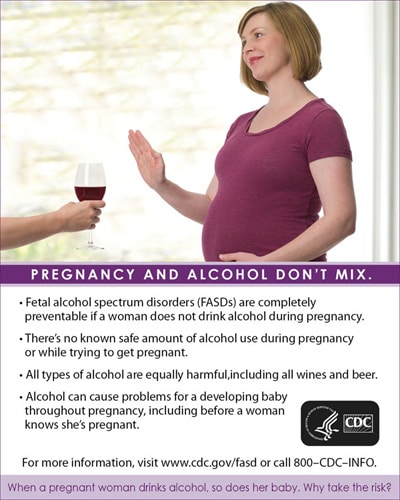 Pregnant woman saying no to a glass of alcohol
