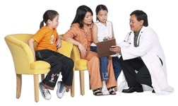 A doctor talking to a mom and two children