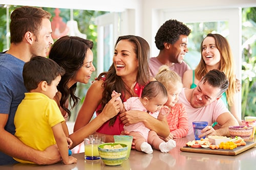Group Of Families Enjoying Snacks At Home