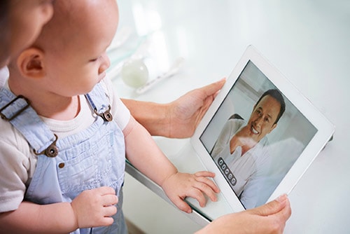 Woman with baby video calling health care provider