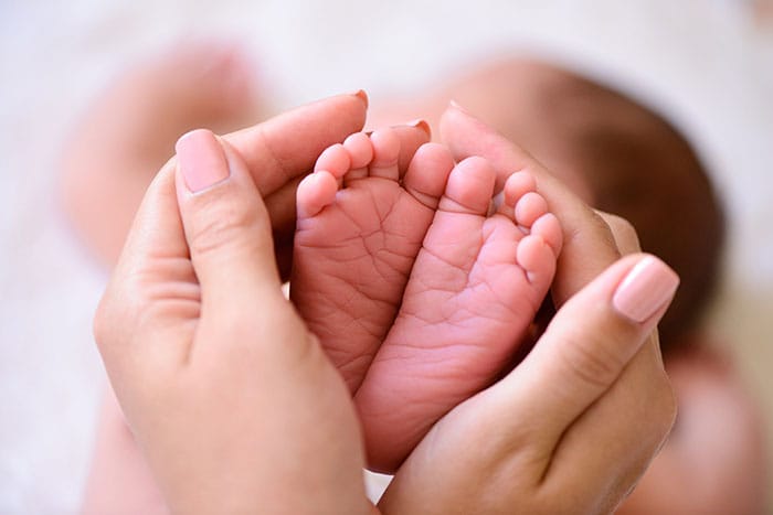 Mother holding her newborn baby's feet