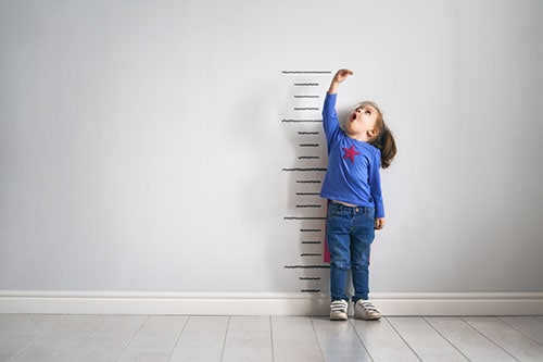 Boy measuring his height on a wall