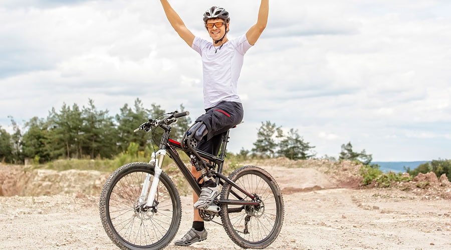 Man with prosthetic led riding mountain bike