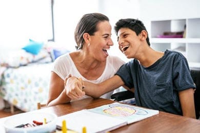 mother with disabled teenager laughing