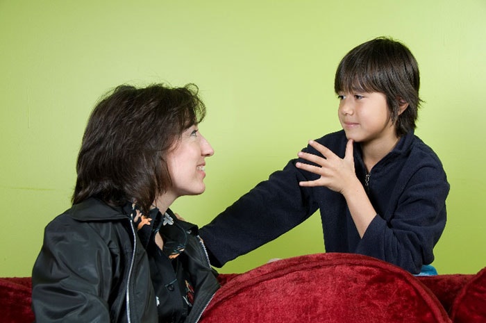 Son using sign language with mother