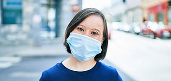 Woman with down syndrome wearing a protective face mask
