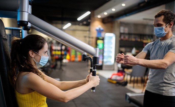 People wearing protective face masks while working out at the gym