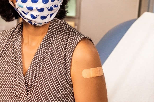 Woman with a bandage on her arm from getting a vaccine