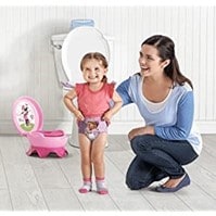 A young child toilet training with her mother
