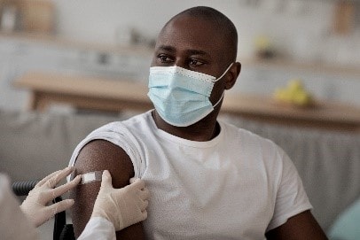 A man wearing a protective face mask while getting a vaccine