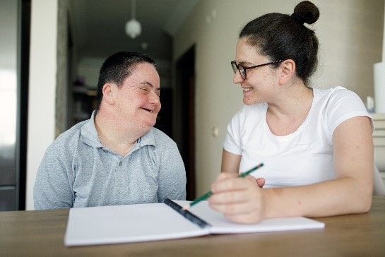 Man with down syndrome working with caregiver