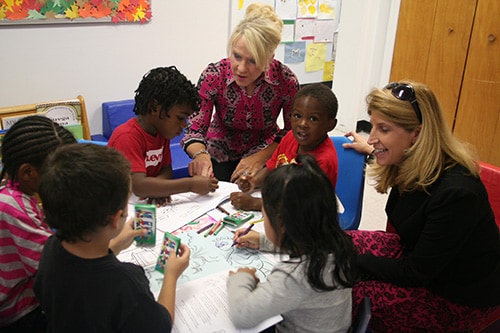 Dr. Rattay (right) helps children with a fun learning activity