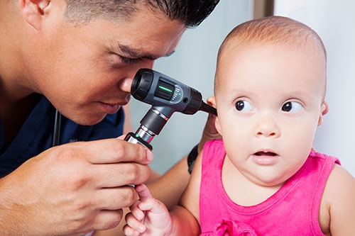 Doctor examines baby's ear