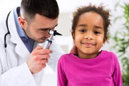 A doctor checking a girls ear