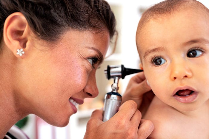 A doctor examining a baby's ear