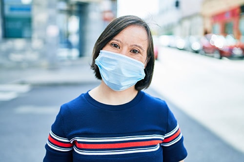 A woman with down syndrome wearing a protective face mask