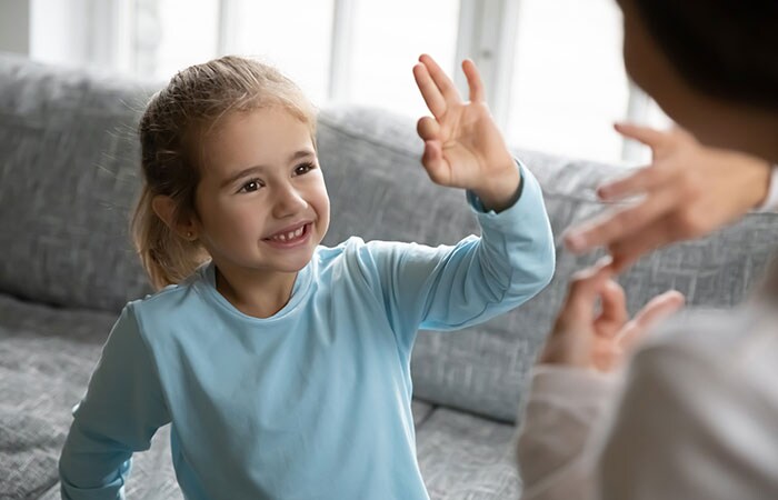 Young girl with hearing loss communicating with her mom using sign language