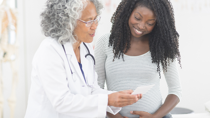 African American doctor and pregnant woman talking