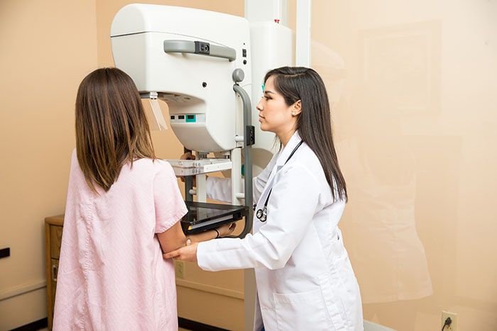 El paciente de ayuda del doctor consigue una mamografía