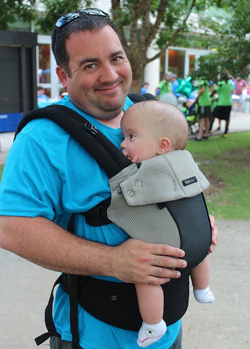 Father holding his baby in a chest baby carrier