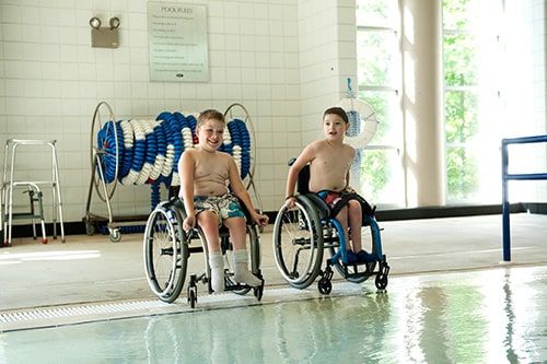 Two boys in wheelchairs at Lakeshore Pool
