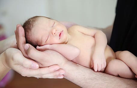 Newborn sleeping in parents hands