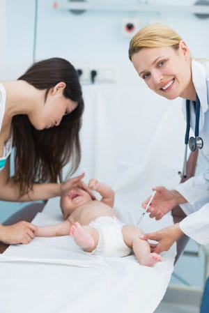 Doctor giving a shot to a newborn baby